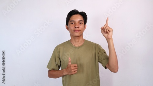 young asian man smiling okay gesture and pointing up
