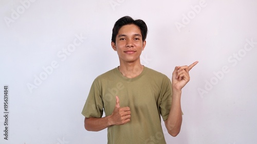 Asian young man smiling okay gesture and pointing to the side