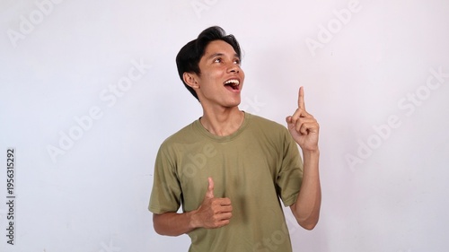young asian man smiling ok gesture, pointing and looking up on