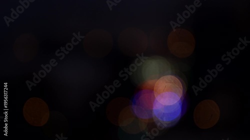 Colorful bokeh lights in urban night scene, out-of-focus city lights, atmospheric street illumination, abstract light patterns