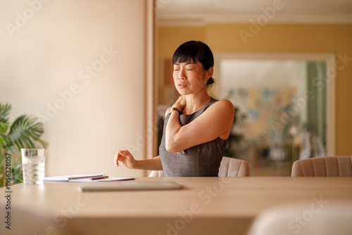 Принти на полотні Young businesswoman with eyes closed experiencing back pain due to prolonged sit
