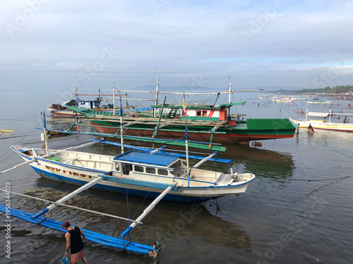 Fishing boats are anchored on the shallow beach in a coastal fishing community.