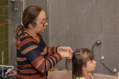 Braiding wet child hair in bathroom