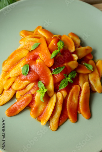 Italian pasta with tomato sauce and basil on green plate, traditional food lifestyle concept