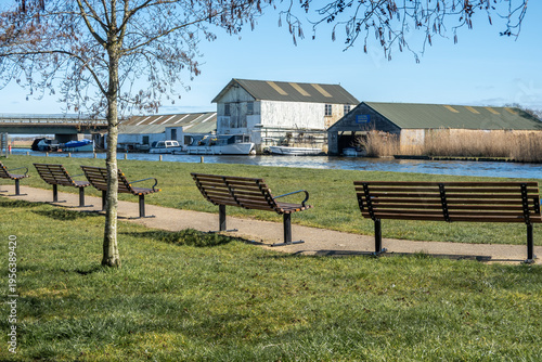 Εκτύπωση καμβά Benches on the river bank beside the River Thurne in Potter Heigham, Norfolk Bro