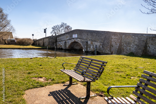 Εκτύπωση καμβά Wooden seating beside the River Thurne and Potter Heigham Bridge, Norfolk Broads