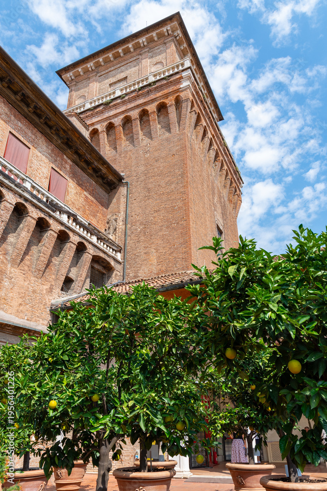 Fototapeta premium Estense Castle (Castello Estense di Ferrara, castello di San Michele, St. Michael's castle) in Ferrara old city center - Garden of the oranges