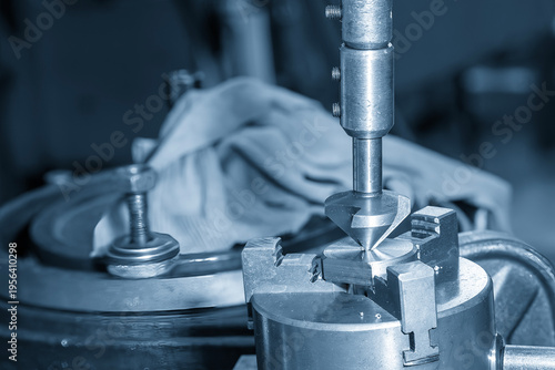 Fotografie Close-up of a manual hole chamfering process on precision metal parts using a hand deburring tool in a blue-toned workshop