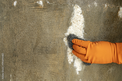 Canvas-taulu Close-Up of a Hand Wearing Bright Orange Protective Rubber Glove Vigorously Scru