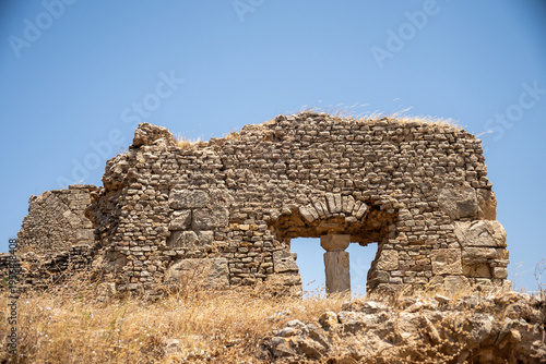 Column visible through a window in a wall in Bulla Regia, outside of Jendouba, Tunisia