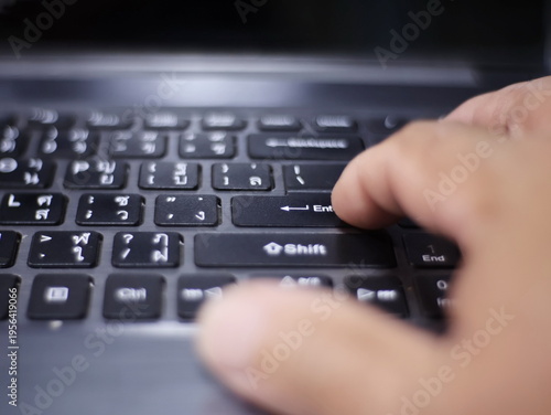 Foto An image of a hand pressing the Enter key on a black laptop keyboard