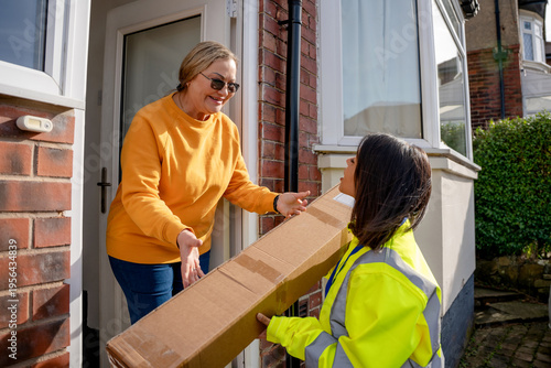 фотографія Delivery person hands package to resident at home entrance during daytime