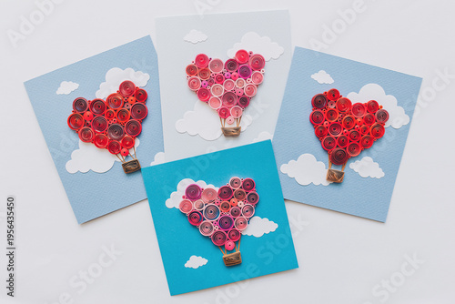 quilling cards with heart balloons between the clouds. Happy valentine day. making greeting cards. Hand made of paper quilling technique. Hobby, home office. Heart from colored paper ribbons