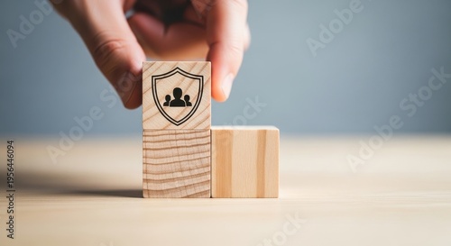 A hand placing a wooden block with a shield and user icon, representing data protection and personal security