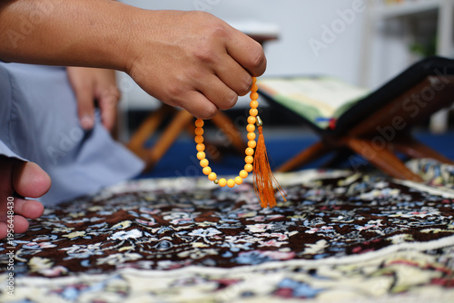 Close-up of hands reciting dhikr using prayer beads. Hands reciting dhikr. A man reciting dhikr while holding prayer beads. A Muslim's worship activity.
