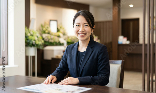 セレモニーホールで笑顔で事前相談に応じる女性葬祭プランナー