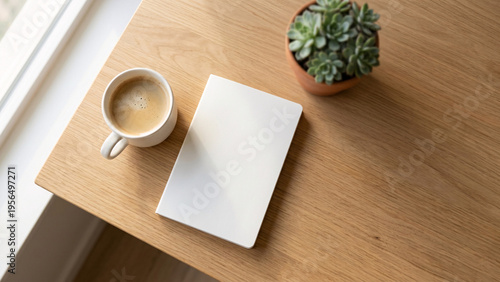 Top view mockup of a blank white notebook on a wooden desk with coffee and a succulent plant.