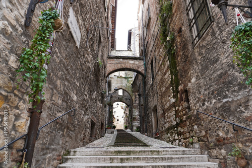 Picturesque alley with stairs in the medieval town of Narni. Umbria region, central Italy. Medieval city: a typical old street. Holidays in Italy. Ancient italian city rich in history. A cobblestone s