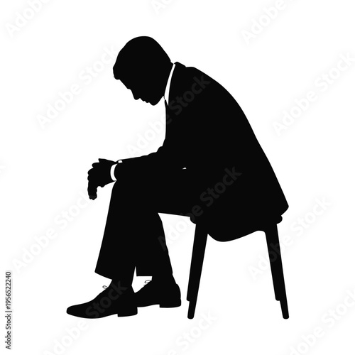 Silhouette of a man sitting slumped in a chair appearing distressed