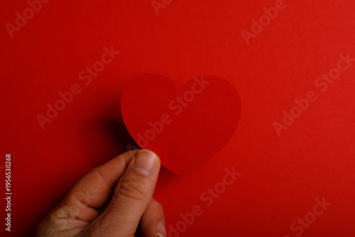 A hand holding a red paper ...