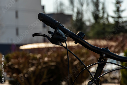 Фотография Bicycle handlebar close-up on a blurred city background, urban lifestyle
