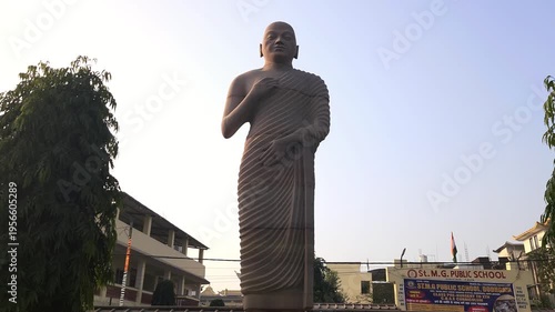Standing Buddha statue in outdoor setting in India. Symbol of peace, meditation, and spirituality. Buddhist sculpture in temple or public area representing calmness, enlightenment, Bodh Gaya, Bihar.