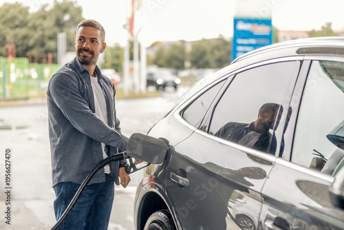 Foto Man filling up car with fuel at gas station