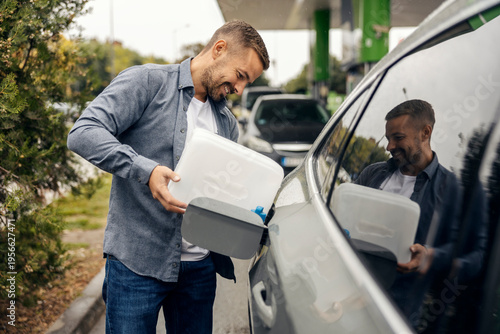 Quadro su tela Man pouring fuel from jerry can into car tank