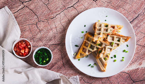 Bacon, cheese and tomatoes baked in waffle bread on a plate on the table top view web banner
