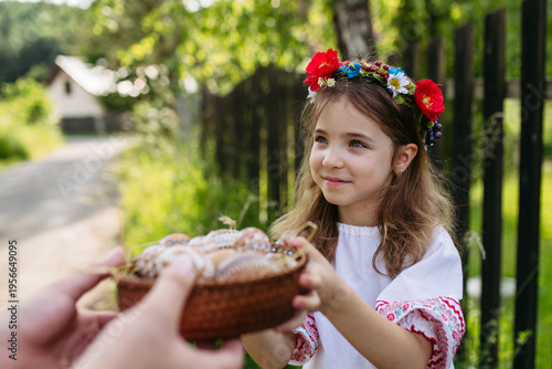 Fotografie Young girl holding traditionally decorated Easter eggs with folk patterns