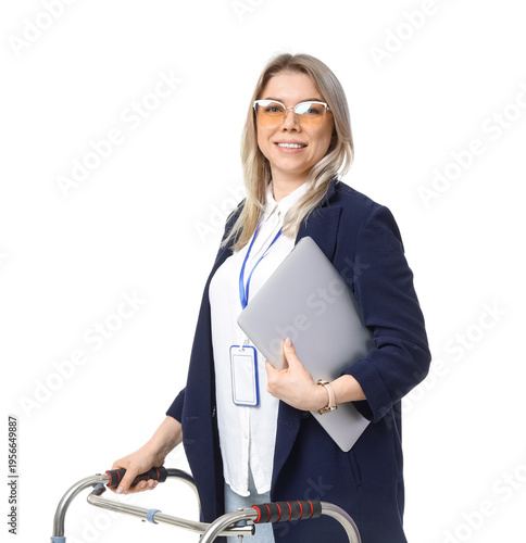 Fotografía Young businesswoman with laptop and walker on white background