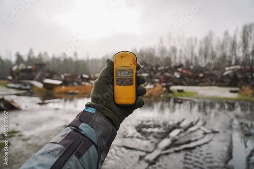 Schilderij op canvas Dosimeter in hand on background museum of special equipment that helped cleaning Chernobyl nuclear power plant after explosion
