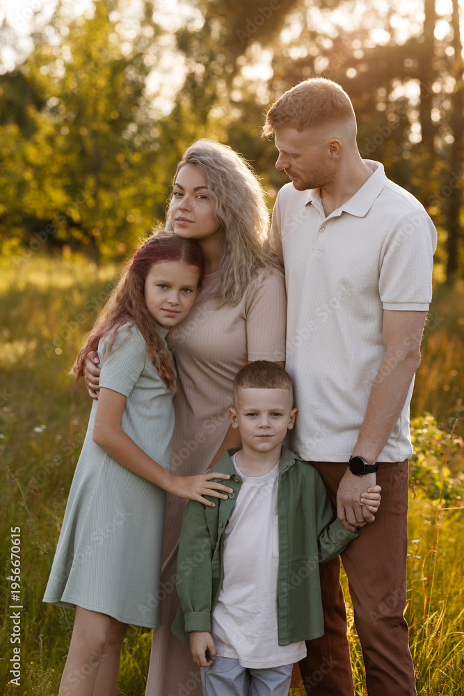 Fototapeta premium Caucasian Family Embracing In Sunlit Meadow, Mother And Father Holding Children Close, Golden Glow, Soft Smiles, Summer Dresses, Intimate Parental Bond Conveying Family Values