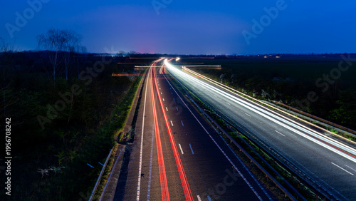 Foto Long exposure highway light trails at dusk