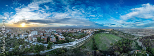 Dramatic aerial panorama of Lucera town and castle with blue, orange, yellow sunrise sky in Puglia