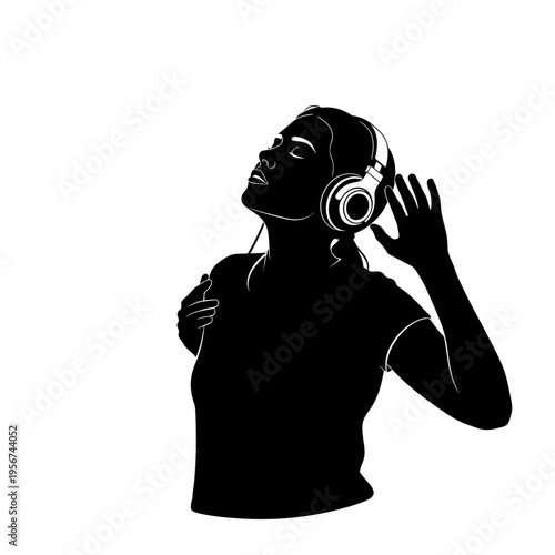 A woman wearing headphones listens to music with her hand raised.