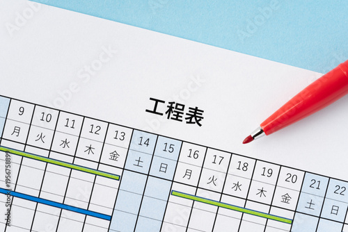 水色背景に工程表と赤いペン