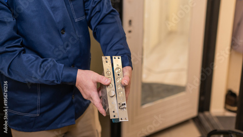 The technician changes the lock on the front door.