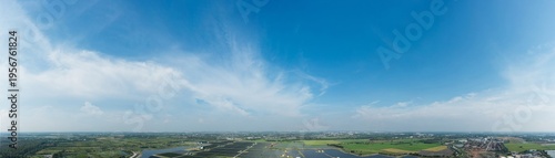 Canvas Print Panoramic wide-angle view blue sky with soft clouds over green rural landscape a