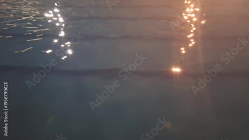 Dark Blue Swimming Pool Water Rippling with Artificial Golden and White Light Reflections