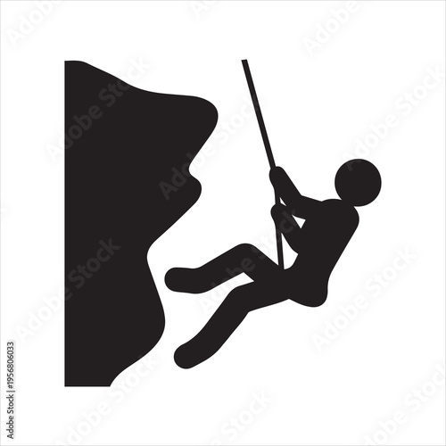 Silhouette of a rock climber rappelling down a cliff face with rope