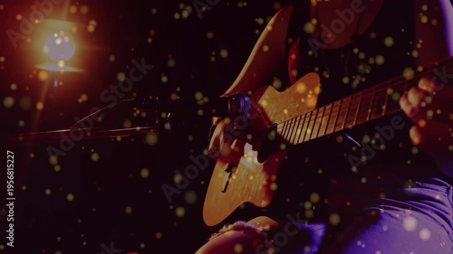 Camera panning inward, revealing woman musician performing, strumming, miking, bokeh persisting