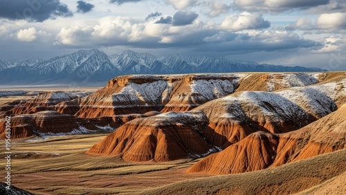 A breathtaking landscape of snow-covered red rock formations under a cloudy sky