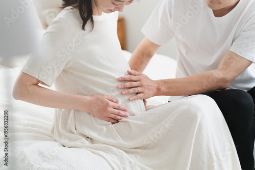 ベッドでくつろいでいる妊婦と夫　ライフスタイルイメージ