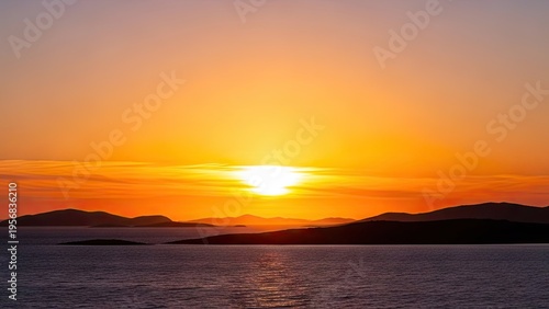 A serene sunset over a calm body of water with mountains in the distance