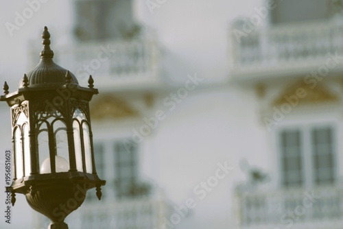 old , vintage street lantern against blurred white building 