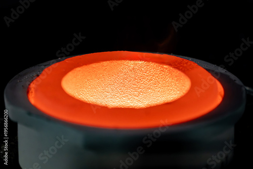Quadro em tela Close up of molten metal being poured into a heated crucible during casting showing intense heat, flame, and thermal energy