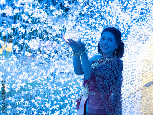 Tourists costume in Thai traditional style standing in LED light tunnel at Na Satta Park, Thailand