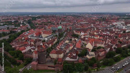 Aerial drone view of Nuremberg old town in Germany with historic buildings, red roofs and medieval architecture. Scenic European cityscape under cloudy sky. 