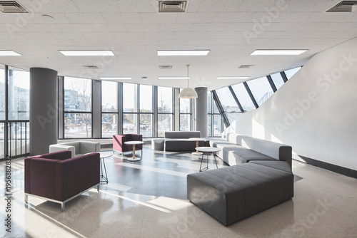 Open lounge with sofas and broad windows in contemporary public building